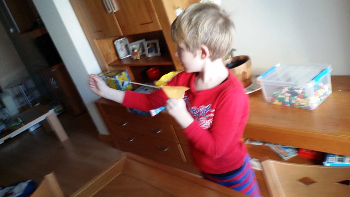 Niño lanzando el avión con la goma